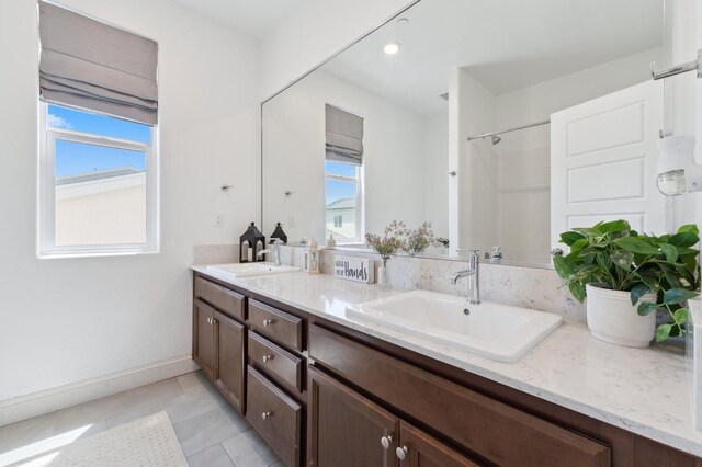 6406 E Giavanna Ave, Fresno, CA 93727 - bathroom featuring double vanity, a shower, tile patterned floors, and recessed lighting