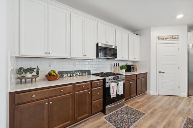 6406 E Giavanna Ave, Fresno, CA 93727 - kitchen featuring appliances with stainless steel finishes, white cabinets, light countertops, tasteful backsplash, and recessed lighting
