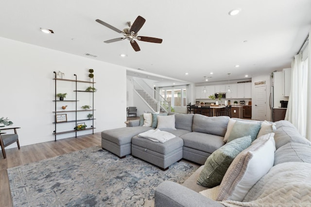 6406 E Giavanna Ave, Fresno, CA 93727 - living area featuring light wood finished floors, ceiling fan, recessed lighting, and stairs