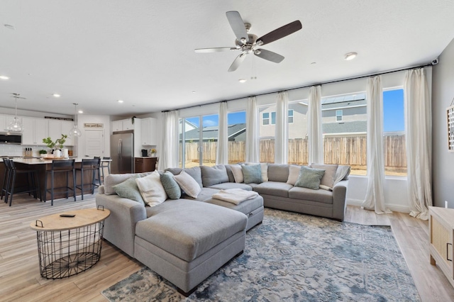 6406 E Giavanna Ave, Fresno, CA 93727 - living room with light wood finished floors, ceiling fan, and recessed lighting
