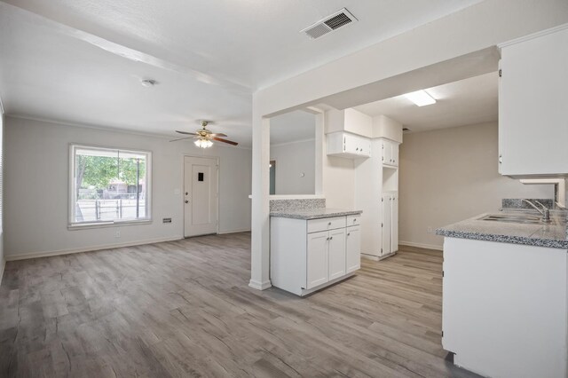 3919 E Butler, Fresno, CA 93702 - kitchen featuring ceiling fan, white cabinets, light wood-type flooring, and light stone counters