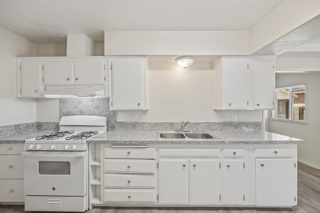 3919 E Butler, Fresno, CA 93702 - kitchen featuring white range with gas stovetop, under cabinet range hood, white cabinets, and light wood-style flooring