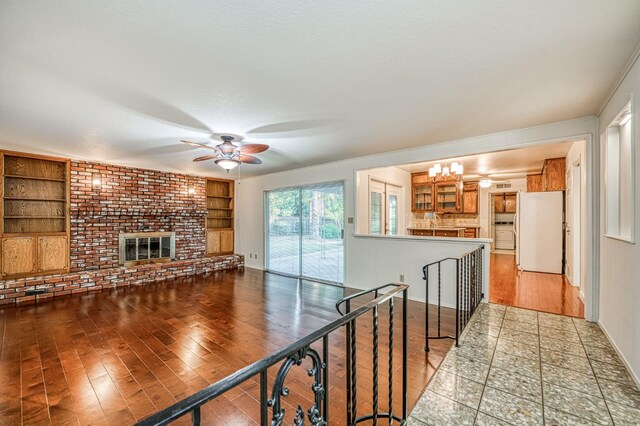 6482 N 5th St, Fresno, CA 93710 - unfurnished living room with a ceiling fan, wood finished floors, built in features, and a fireplace