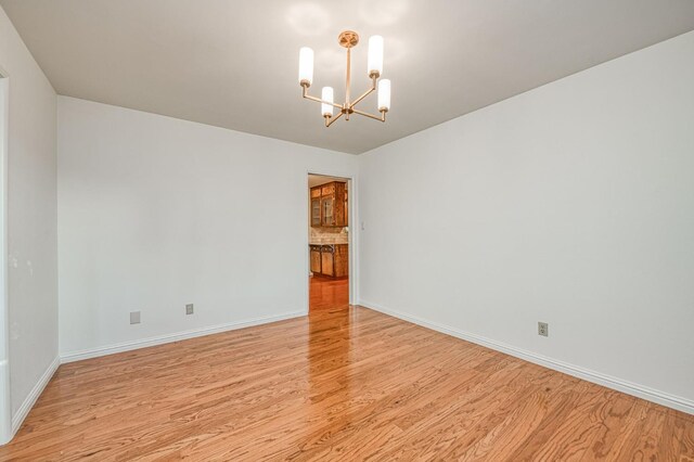 6482 N 5th St, Fresno, CA 93710 - empty room with a chandelier and light wood-type flooring