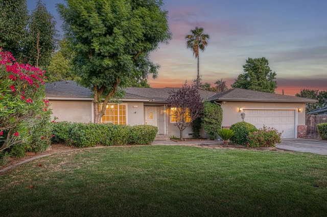 6482 N 5th St, Fresno, CA 93710 - view of front facade featuring stucco siding, a yard, concrete driveway, and a garage