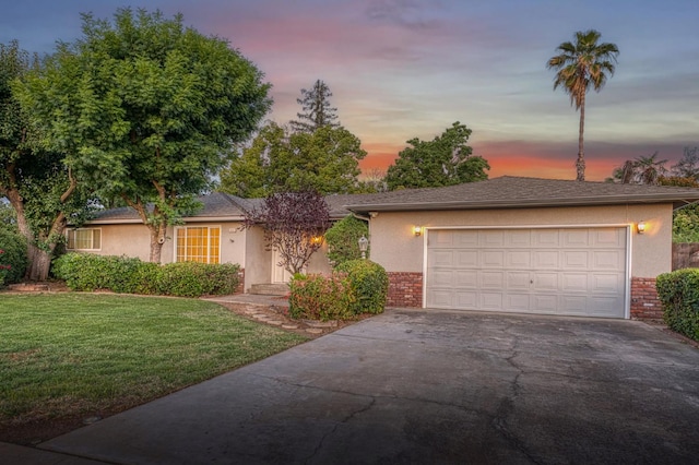 6482 N 5th St, Fresno, CA 93710 - view of front facade featuring brick siding, driveway, a front lawn, stucco siding, and a garage