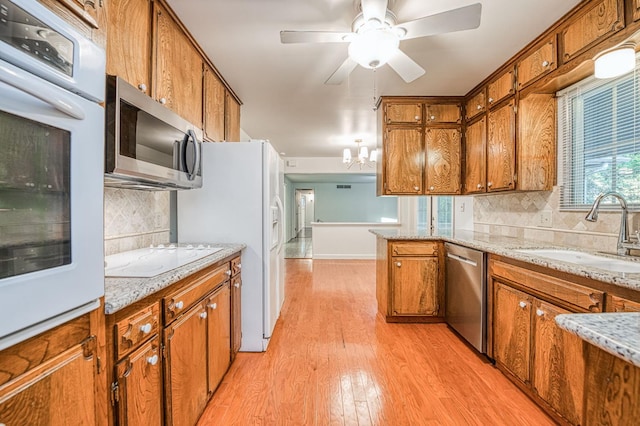 6482 N 5th St, Fresno, CA 93710 - kitchen with stainless steel appliances, brown cabinets, light wood finished floors, decorative backsplash, and a ceiling fan