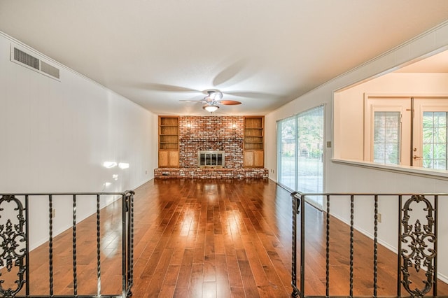 6482 N 5th St, Fresno, CA 93710 - unfurnished living room featuring a ceiling fan, a brick fireplace, hardwood / wood-style flooring, and healthy amount of natural light