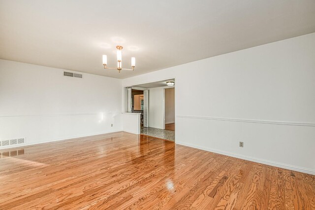 6482 N 5th St, Fresno, CA 93710 - spare room featuring wood finished floors and a chandelier