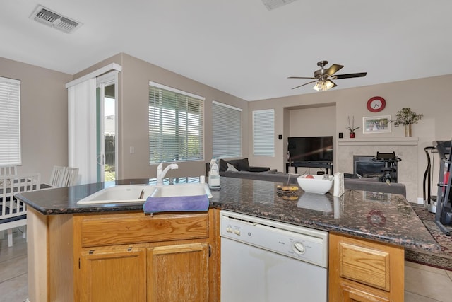 1085 Stanford Ave, Madera, CA 93637 - kitchen with white dishwasher, light tile patterned flooring, open floor plan, ceiling fan, and a tiled fireplace
