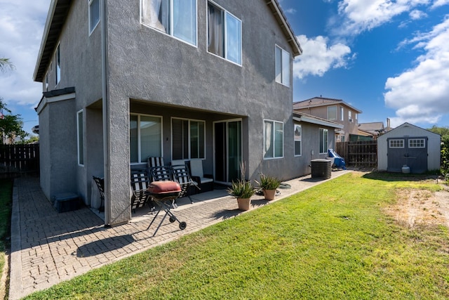 1085 Stanford Ave, Madera, CA 93637 - back of property with stucco siding, a patio area, a storage shed, and a fenced backyard