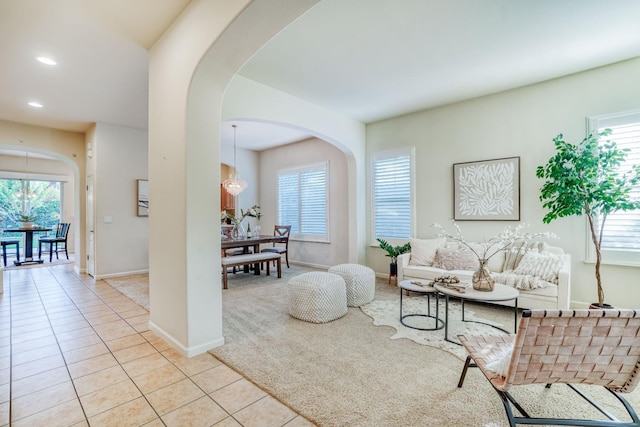 3202 Everglade Ave, Clovis, CA 93619 - living room with arched walkways, healthy amount of natural light, recessed lighting, light tile patterned floors, and light colored carpet