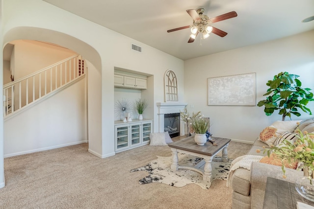 3202 Everglade Ave, Clovis, CA 93619 - living area with a glass covered fireplace, ceiling fan, stairway, and carpet flooring