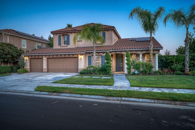 3202 Everglade Ave, Clovis, CA 93619 - mediterranean / spanish-style home featuring a tile roof, stucco siding, a front lawn, and roof mounted solar panels