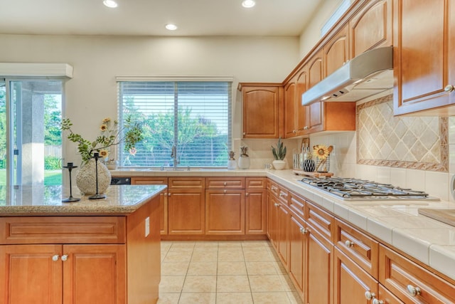 3202 Everglade Ave, Clovis, CA 93619 - kitchen with under cabinet range hood, stainless steel gas stovetop, decorative backsplash, recessed lighting, and light tile patterned floors