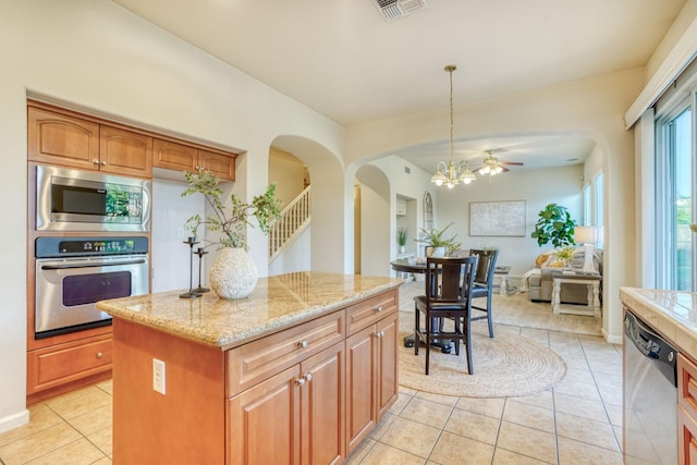 3202 Everglade Ave, Clovis, CA 93619 - kitchen with appliances with stainless steel finishes, light tile patterned floors, arched walkways, and a center island