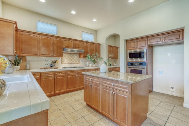 3202 Everglade Ave, Clovis, CA 93619 - kitchen featuring stainless steel appliances, tile countertops, light tile patterned floors, tasteful backsplash, and under cabinet range hood
