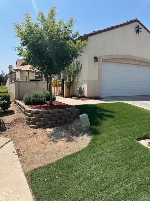 2400 Garda Corte, Chowchilla, CA 93610 - mediterranean / spanish-style house with stucco siding, an attached garage, and driveway
