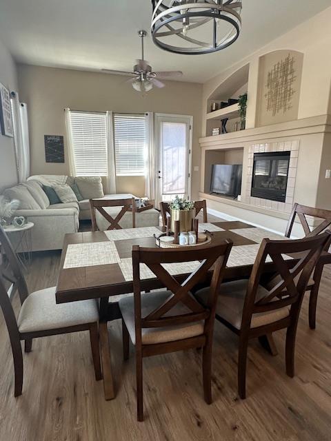 2400 Garda Corte, Chowchilla, CA 93610 - dining room with a ceiling fan, wood finished floors, a tile fireplace, and a chandelier