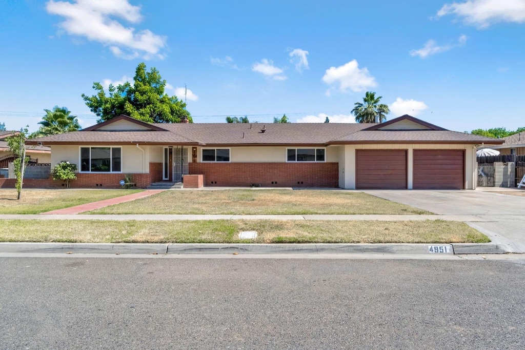 4951 E Townsend Ave, Fresno, CA 93727 - ranch-style home with an attached garage, brick siding, concrete driveway, a front lawn, and stucco siding