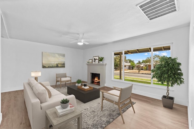644 W Yale Ave, Fresno, CA 93705 - living area featuring a fireplace, wood finished floors, and a ceiling fan