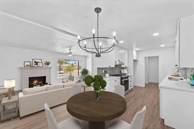 644 W Yale Ave, Fresno, CA 93705 - dining room featuring a fireplace, a chandelier, light wood-style flooring, ceiling fan, and recessed lighting
