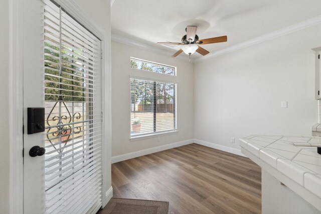 2261 Magill Ave, Clovis, CA 93611 - unfurnished dining area with ceiling fan, ornamental molding, and wood finished floors