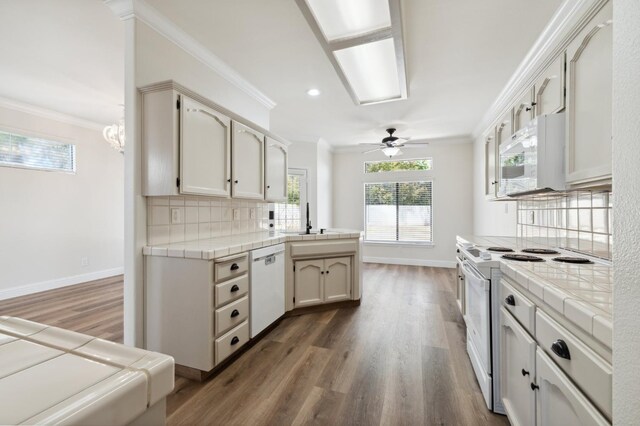 2261 Magill Ave, Clovis, CA 93611 - kitchen featuring white appliances, tile countertops, dark wood finished floors, decorative backsplash, and crown molding