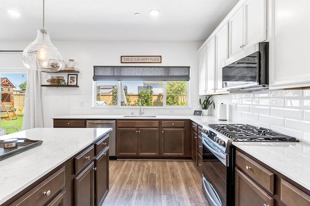 827 Vintage Ave, Clovis, CA 93619 - kitchen featuring appliances with stainless steel finishes, light wood finished floors, white cabinets, tasteful backsplash, and dark brown cabinets