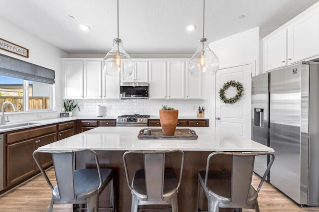 827 Vintage Ave, Clovis, CA 93619 - kitchen with appliances with stainless steel finishes, light wood finished floors, white cabinetry, decorative backsplash, and recessed lighting