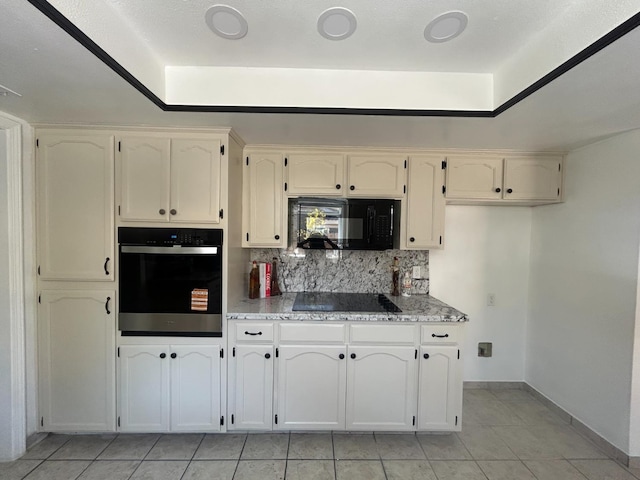 6536 N Tracy Ave, Fresno, CA 93722 - kitchen featuring black appliances, light tile patterned floors, tasteful backsplash, light countertops, and a tray ceiling