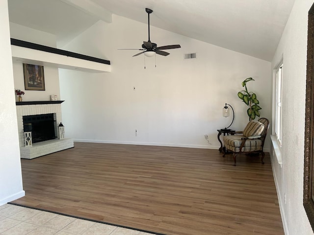 6536 N Tracy Ave, Fresno, CA 93722 - unfurnished living room featuring ceiling fan, beam ceiling, high vaulted ceiling, wood finished floors, and a fireplace