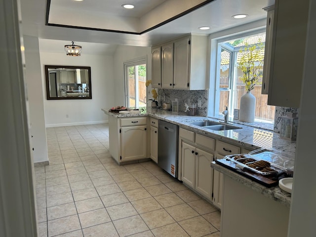 6536 N Tracy Ave, Fresno, CA 93722 - kitchen featuring dishwasher, decorative backsplash, a peninsula, light tile patterned flooring, and a raised ceiling