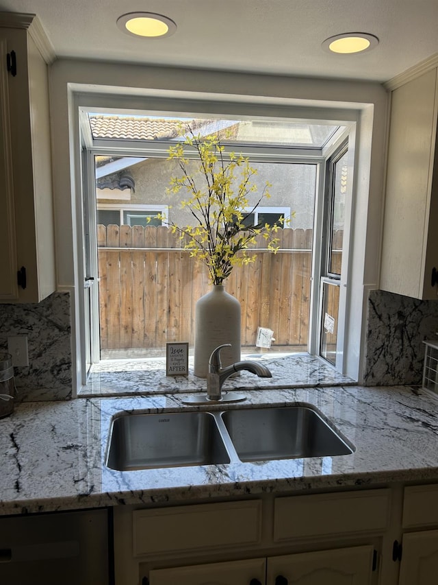 6536 N Tracy Ave, Fresno, CA 93722 - kitchen view of decorative backsplash, light stone counters, and stainless steel dishwasher