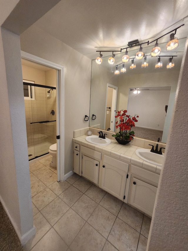6536 N Tracy Ave, Fresno, CA 93722 - bathroom featuring a shower stall, double vanity, and tile patterned floors