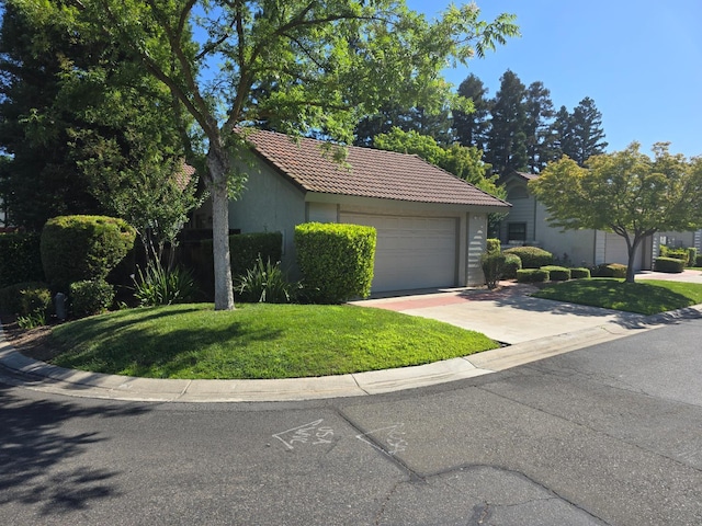 1229 W Bullard Ave Unit 105, Fresno, CA 93711 - view of front of house with a garage, a tile roof, a front yard, and stucco siding