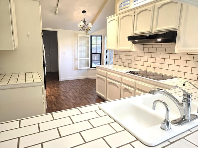 1229 W Bullard Ave Unit 105, Fresno, CA 93711 - kitchen featuring black electric stovetop, tile countertops, exhaust hood, backsplash, and dark wood-style floors