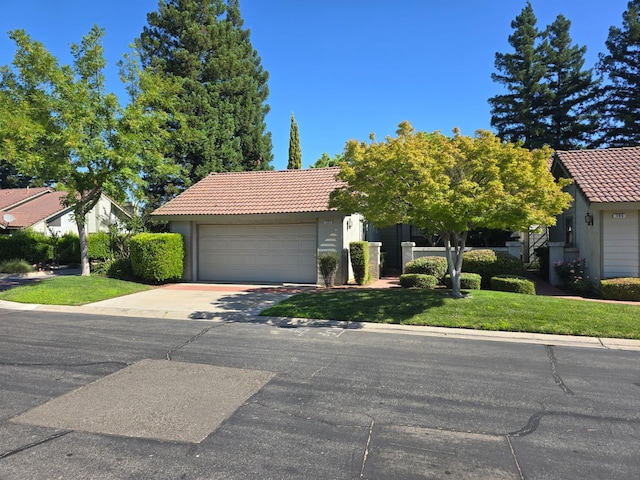 1229 W Bullard Ave Unit 105, Fresno, CA 93711 - view of property hidden behind natural elements with a tiled roof, an attached garage, stucco siding, and concrete driveway