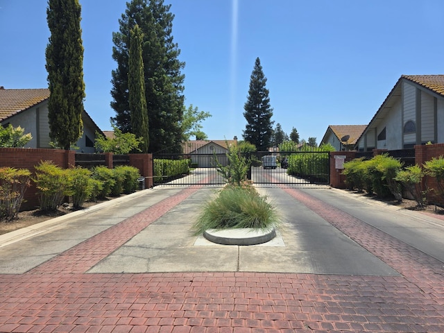 1229 W Bullard Ave Unit 105, Fresno, CA 93711 - view of decorative road with a gated entry, a gate, curbs, and a residential view