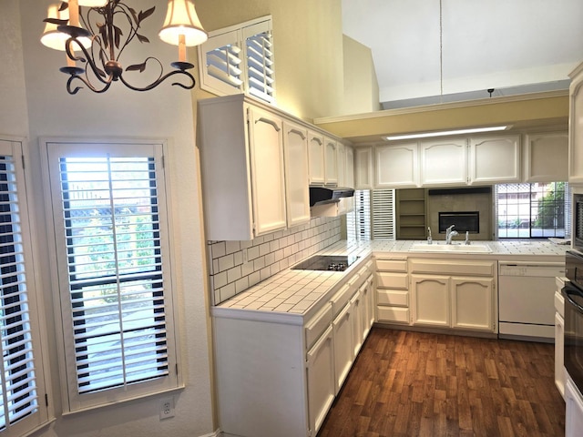1229 W Bullard Ave Unit 105, Fresno, CA 93711 - kitchen with tile counters, tasteful backsplash, white dishwasher, dark wood-style floors, and a chandelier
