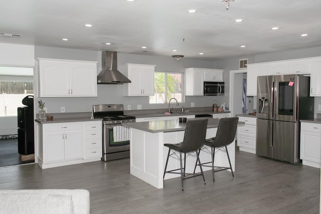 19244 W Casmalia, Rialto, CA 92377 - kitchen with stainless steel appliances, wall chimney range hood, a breakfast bar area, white cabinets, and dark wood finished floors