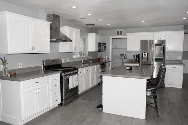 19244 W Casmalia, Rialto, CA 92377 - kitchen with appliances with stainless steel finishes, wall chimney exhaust hood, washer and clothes dryer, white cabinetry, and recessed lighting
