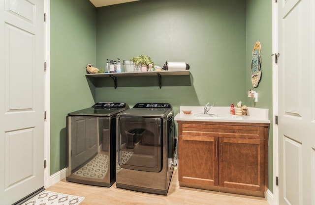 2047 Menlo Ave, Clovis, CA 93611 - laundry room featuring washer and dryer, light wood-style floors, and cabinet space