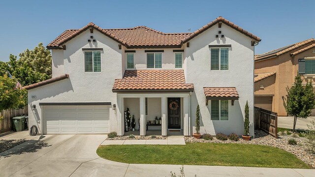 2047 Menlo Ave, Clovis, CA 93611 - mediterranean / spanish house featuring a tiled roof, a garage, driveway, and stucco siding