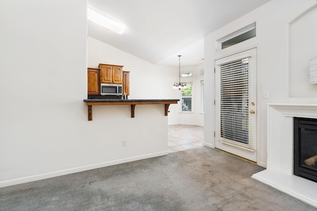 10643 N Tea Party Ln, Fresno, CA 93730 - unfurnished living room with a glass covered fireplace, vaulted ceiling, and light carpet