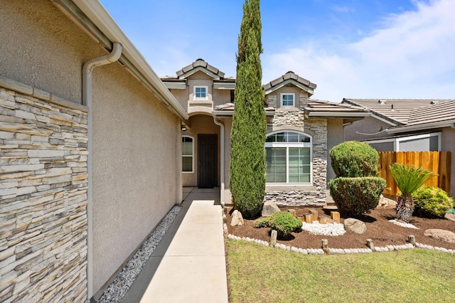 10643 N Tea Party Ln, Fresno, CA 93730 - view of exterior entry with stone siding, stucco siding, and a tiled roof