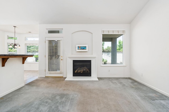 10643 N Tea Party Ln, Fresno, CA 93730 - unfurnished living room with carpet, a glass covered fireplace, and a chandelier