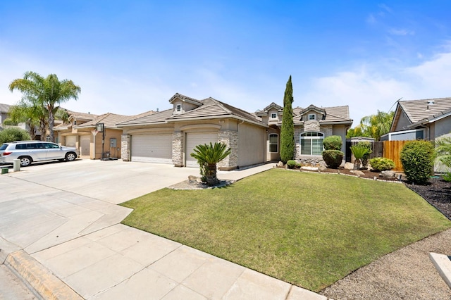 10643 N Tea Party Ln, Fresno, CA 93730 - view of front facade featuring stone siding, a garage, driveway, a tiled roof, and stucco siding