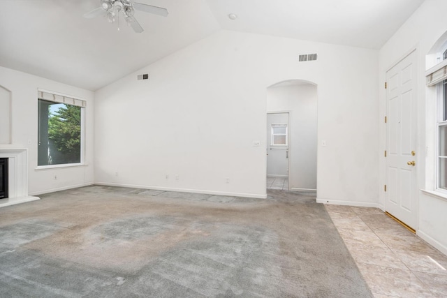10643 N Tea Party Ln, Fresno, CA 93730 - unfurnished living room with arched walkways, a ceiling fan, high vaulted ceiling, a glass covered fireplace, and light carpet