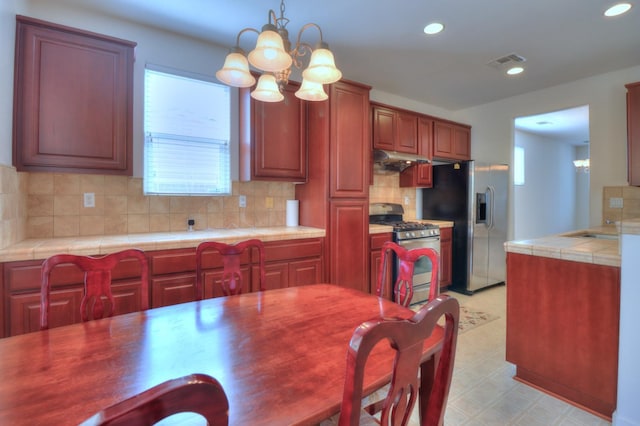 2062 Dunbar Way, Dinuba, CA 93618 - kitchen featuring appliances with stainless steel finishes, healthy amount of natural light, tile countertops, recessed lighting, and tasteful backsplash